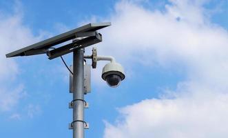 CCTV camera on bright blue sky background,  Concept. 24 hour day and night security photo