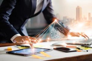 hombre de negocios tocando tableta y computadora portátil. gestión de redes de estructura global e intercambio de datos conexión de clientes en el lugar de trabajo. tecnología empresarial y concepto de red de marketing digital. foto