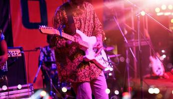 Guitarist on stage with red lighting for blackground. Guitar player, soft and blur concept. photo