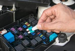 Auto mechanic checking a car fuse photo