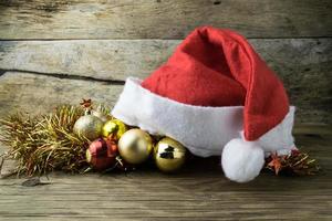 Santa Hat with Christmas decorations on old wooden background. photo