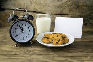 cookies and a glass with milk with a white note for santa photo