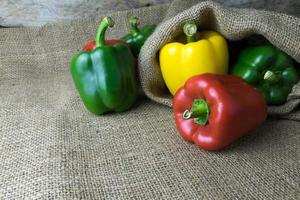 Colored bell peppers on wooden table