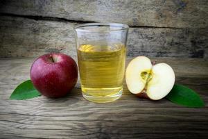 Apple juice and apples on a wooden table photo