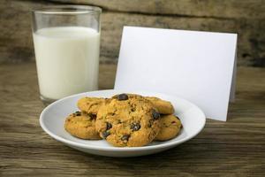 cookies and a glass with milk with a white note for santa photo