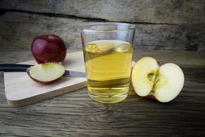 Apple juice and apples on a wooden table photo