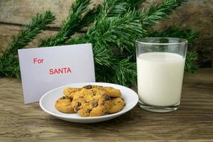 cookies and a glass with milk with a white note for santa photo