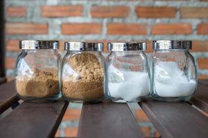 Group set of bottle white sugar and brown sugar on wooden table in cafe. photo