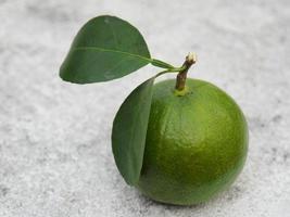 a green fresh lime with leaves on white background photo