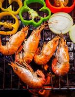 shrimp,prawns grilled on barbecue fire stove with chilly onion for seafood meal photo