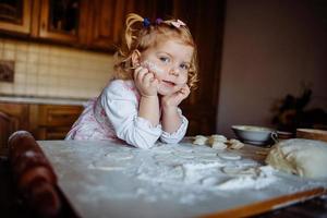 baker girl in chef hat at kitchen photo