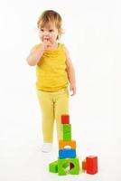little girl playing with colorful toy blocks photo