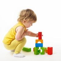 little girl playing with colorful toy blocks