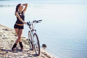 woman on a bicycle near the water photo
