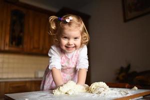 little girl kneading dough photo