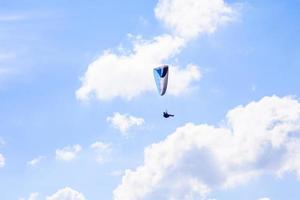 hombre en un paracaídas volando en el cielo despejado