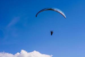 hombre en un paracaídas volando en el cielo despejado