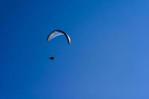 man on a parachute flying in the clear sky photo