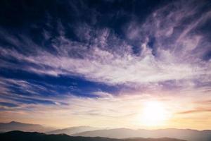 colorful sky with sun background in mountains. photo