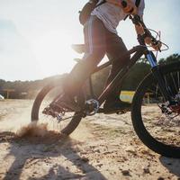 Biker riding along beach at sunset photo