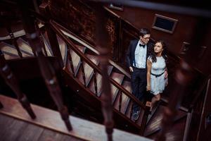 pareja joven de moda de pie en las escaleras y abrazándose unos a otros foto