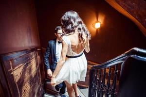 Fashionable young couple standing on stairs and hugging each other photo