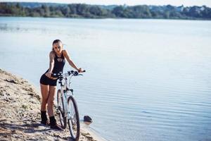 woman on a bicycle near the water photo