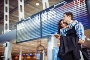 joven pareja amorosa abrazándose en la terminal del aeropuerto. foto