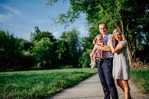 Happy mother, father and daughter in the park photo