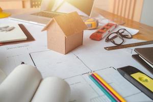 Business objects of architect on desk with engineer tools and architect analyzer working with blueprints and model house,Team meeting concept.Project ideas concept.Vintage effect,selective focus. photo