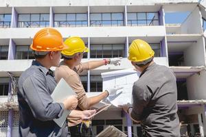 Engineer team and worker checking blueprint for emolition construction plan and inspect at the site. photo