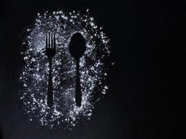 Fork and Spoon IMAGE ABOVE FLOUR, BLACK BACKGROUND. 12 FEBRUARY 2022 INDONESIA photo