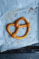 Fresh prepared homemade soft pretzels. Different types of baked bagels with seeds on a black background. photo