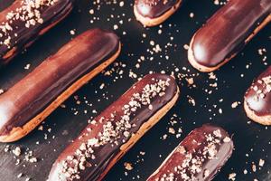 Traditional french eclairs with chocolate. Tasty dessert. Home made cake eclairs. Sweet Dessert Pastry filled with cream. Chocolate icing. photo