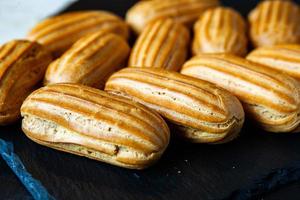 Traditional french eclairs with chocolate. Tasty dessert. Home made cake eclairs. Sweet Dessert Pastry filled with cream. Chocolate icing. photo