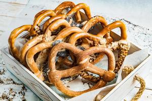 Fresh prepared homemade soft pretzels. Different types of baked bagels with seeds on a black background. photo