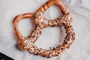 Fresh prepared homemade soft pretzels. Different types of baked bagels with seeds on a black background. photo