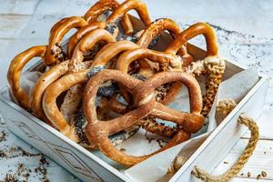 Fresh prepared homemade soft pretzels. Different types of baked bagels with seeds on a black background. photo