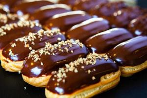 Traditional french eclairs with chocolate. Tasty dessert. Home made cake eclairs. Sweet Dessert Pastry filled with cream. Chocolate icing. photo