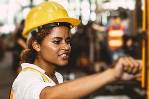 Mujeres negras americanas trabajadoras adolescentes que trabajan en fábricas industriales con máquinas de acero pesado. foto