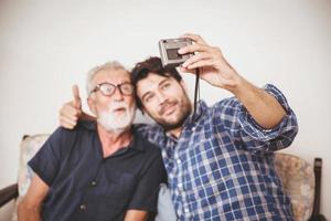 Happy elder, Son take a photo selfie with his uncle happy family with digital camera lifestyle.