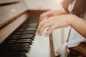 Closeup woman hand playing piano at home vintage colortone. photo