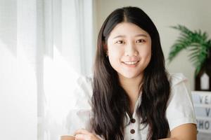 linda adolescente asiática sonriendo en la casa para asia joven ama de casa feliz disfrutar del estilo de vida en casa. foto