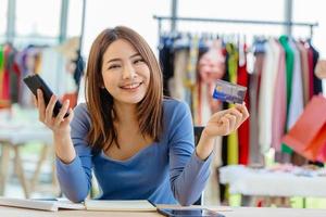 propietario de una tienda inteligente feliz con el pago con tarjeta de crédito y la banca por Internet de teléfonos inteligentes para el pago del cliente foto