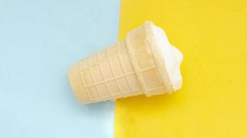 Waffle cup of cream ice cream on pastel blue yellow background. photo