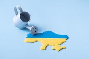 forma de mapa de ucrania en colores amarillo y azul de la bandera nacional y un rociador. infusión, inversión, donaciones en concepto de Ucrania foto