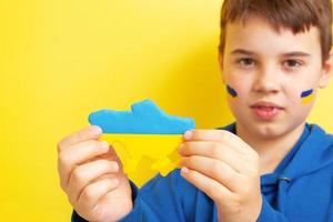 Map of Ukraine in yellow and blue in the hands of a boy photo