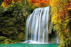 Colorful majestic waterfall in national park forest during autumn photo