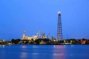 refinería de petróleo al atardecer con reflejo foto