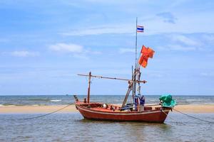 Traditional fishing boat on beach and blue sky photo